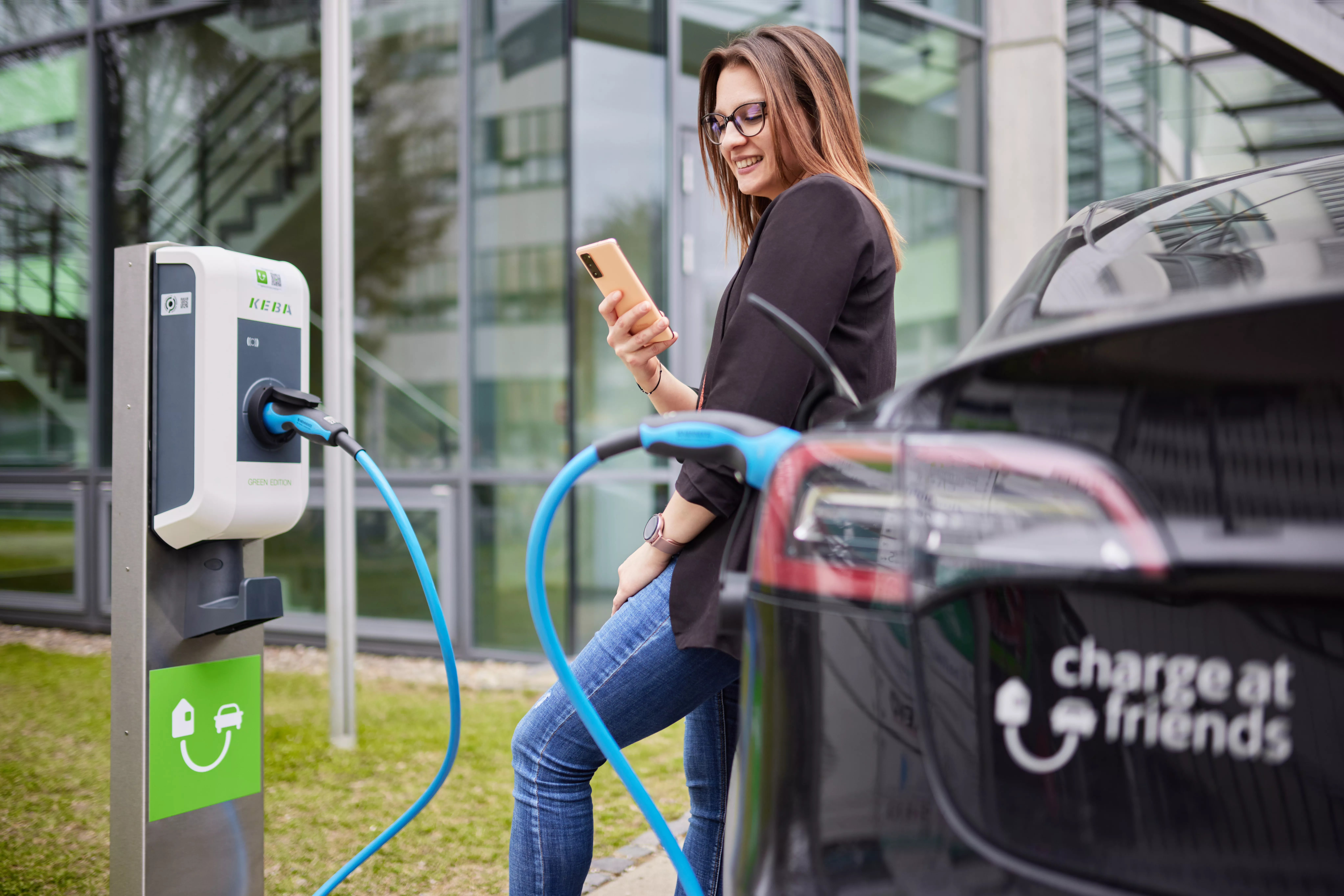 Frau lädt an ChargeAtFriends Ladestation