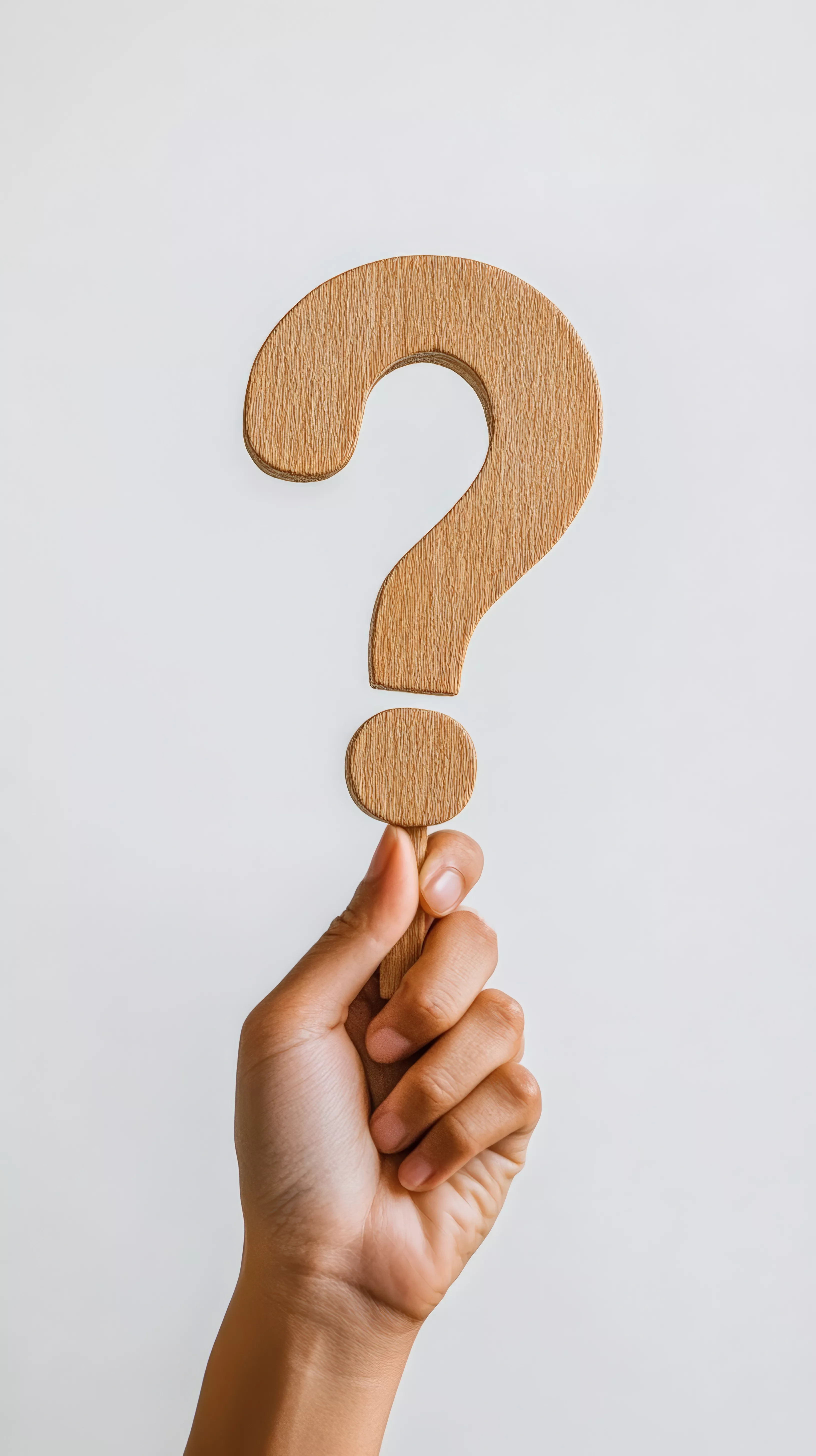 Mensch hält Fragezeichen aus Holz